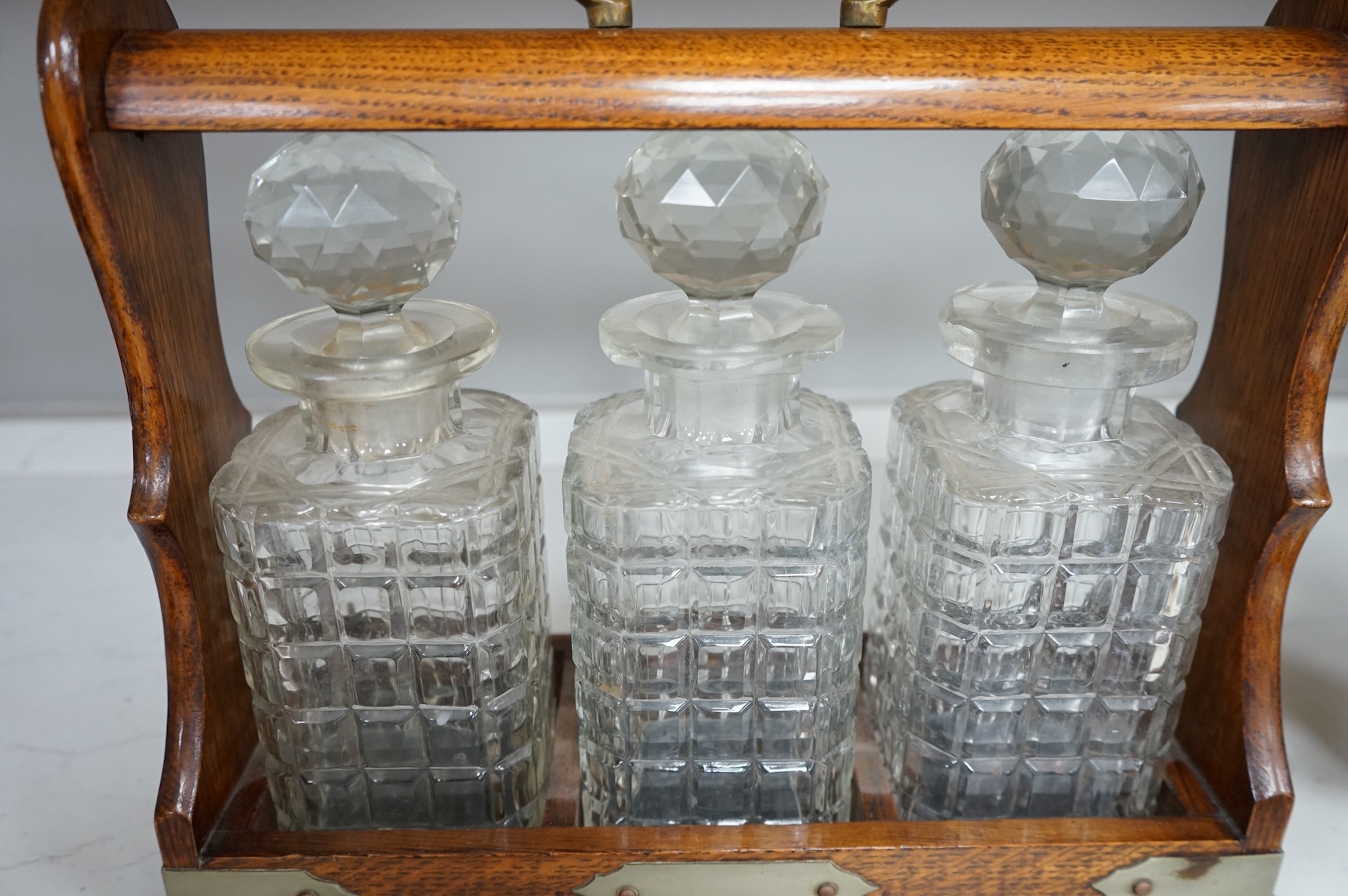 An oak three bottle tantalus, with key, together with three 18th/19th century faience plates and a Royal Worcester jug, tantalus 36cm wide